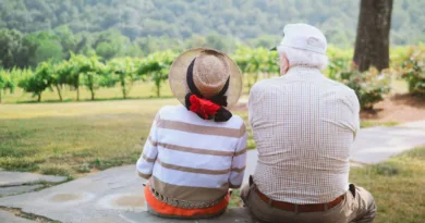 ein älteres Pärchen sitzt und schaut in richtung eines Weinbergs