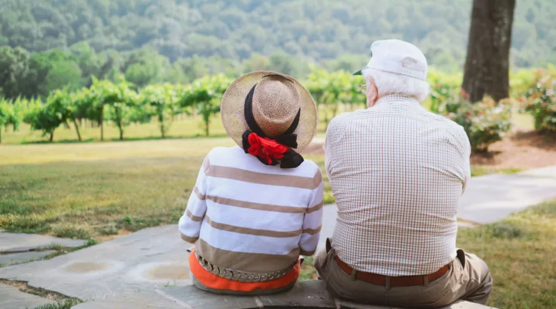 ein älteres Pärchen sitzt und schaut in richtung eines Weinbergs