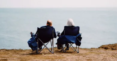 ein älteres Paar sitzt und schaut aufs Meer hinaus
