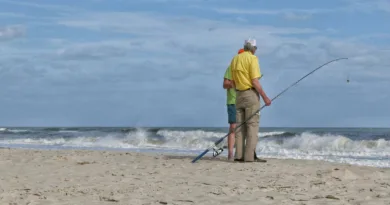 zwei ältere Herren stehen mit einer Angel am Strand