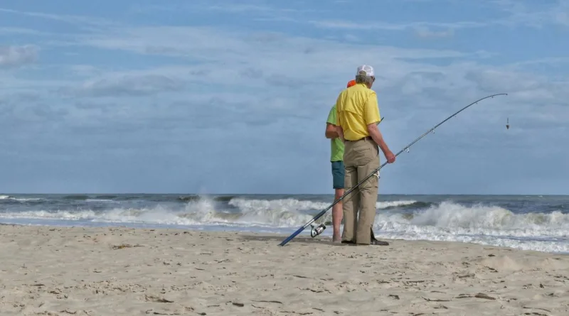 zwei ältere Herren stehen mit einer Angel am Strand