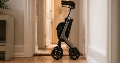 Kompakter dreirädriger Rollator in schmalem Flur, faltbar, seitliche Ansicht